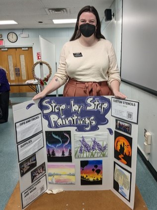 Genevieve Girvan, from the Warren Township Branch of the Somerset County Library System of New Jersey (SCLSNJ), shows off details of her Step-by-Step painting classes for adult patrons, at LibraryLinkNJ's Adult Craft Show & Share event, held Nov. 15, 2022.
